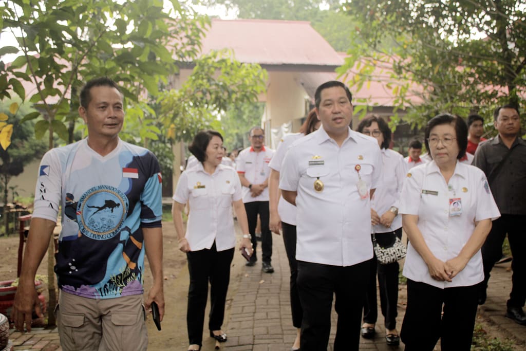 Wakil gubernur berjalan ke dalam sekolah didampingi kepala sekolah beserta rombongan